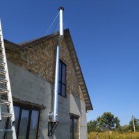 Монтаж зовнішнього димоходу з нержавіючої сталі в будинку, що будується