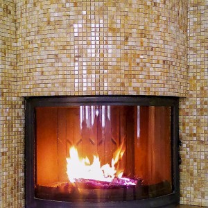 Камін округлої форми з оздобленням з мозаїки